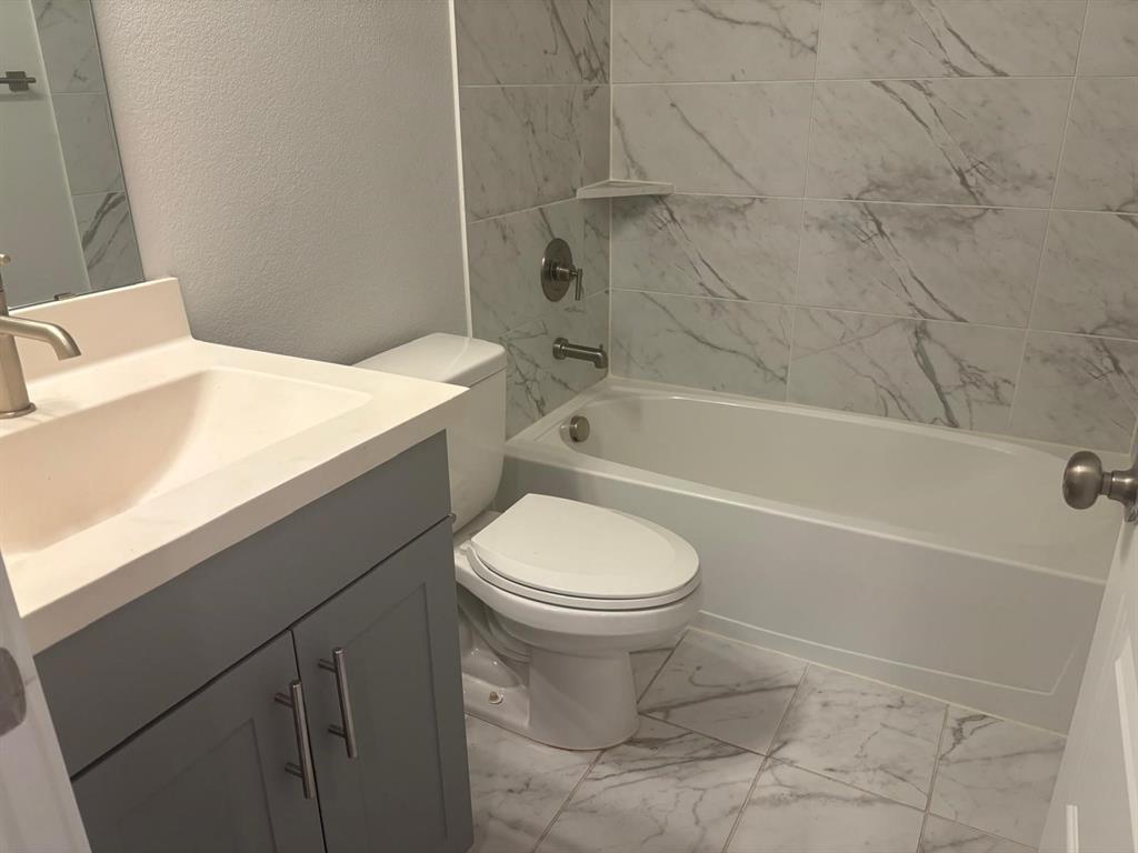 825 West Mayfield Road, Unit 224 Arlington, TX 76015 - Photo 8 of 25 a bathroom with a toilet and a bath tub