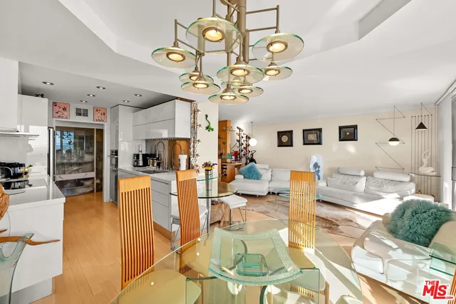 a living room with fireplace dining table and a chandelier