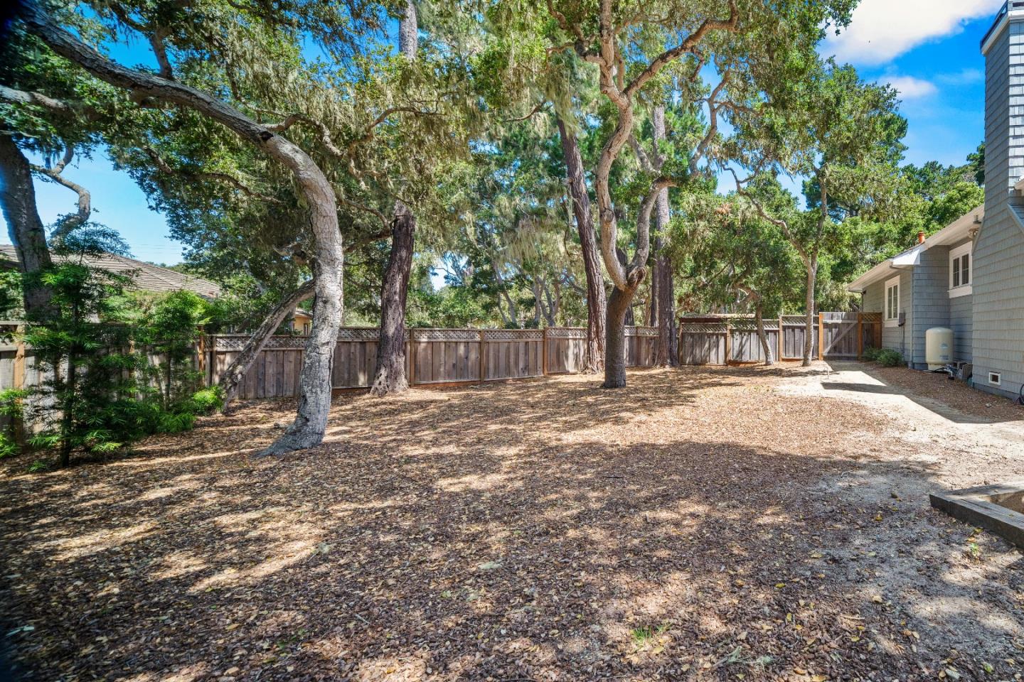 2823 Congress Road Pebble Beach, CA 93953 - Photo 47 of 49 a backyard of a house with large trees and outdoor seating