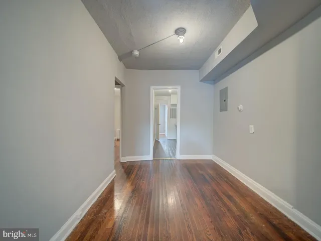 a view of an empty room with wooden floor