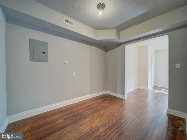 a view of an empty room with wooden floor