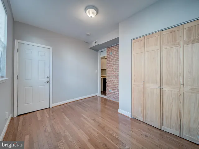 an empty room with wooden floor and closet