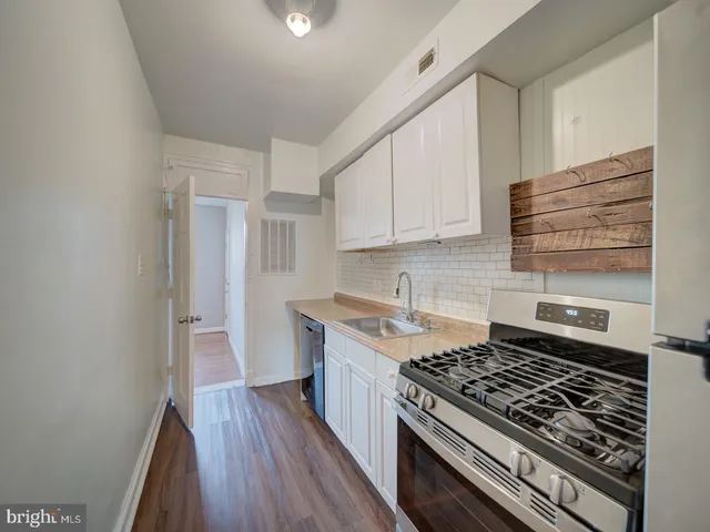 a kitchen with a stove and white cabinets