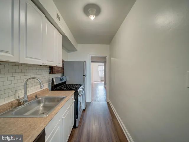 a kitchen with a sink a stove and cabinets