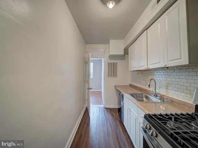 a kitchen with sink a stove and cabinets