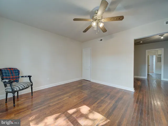 a view of room with wooden floor and fan