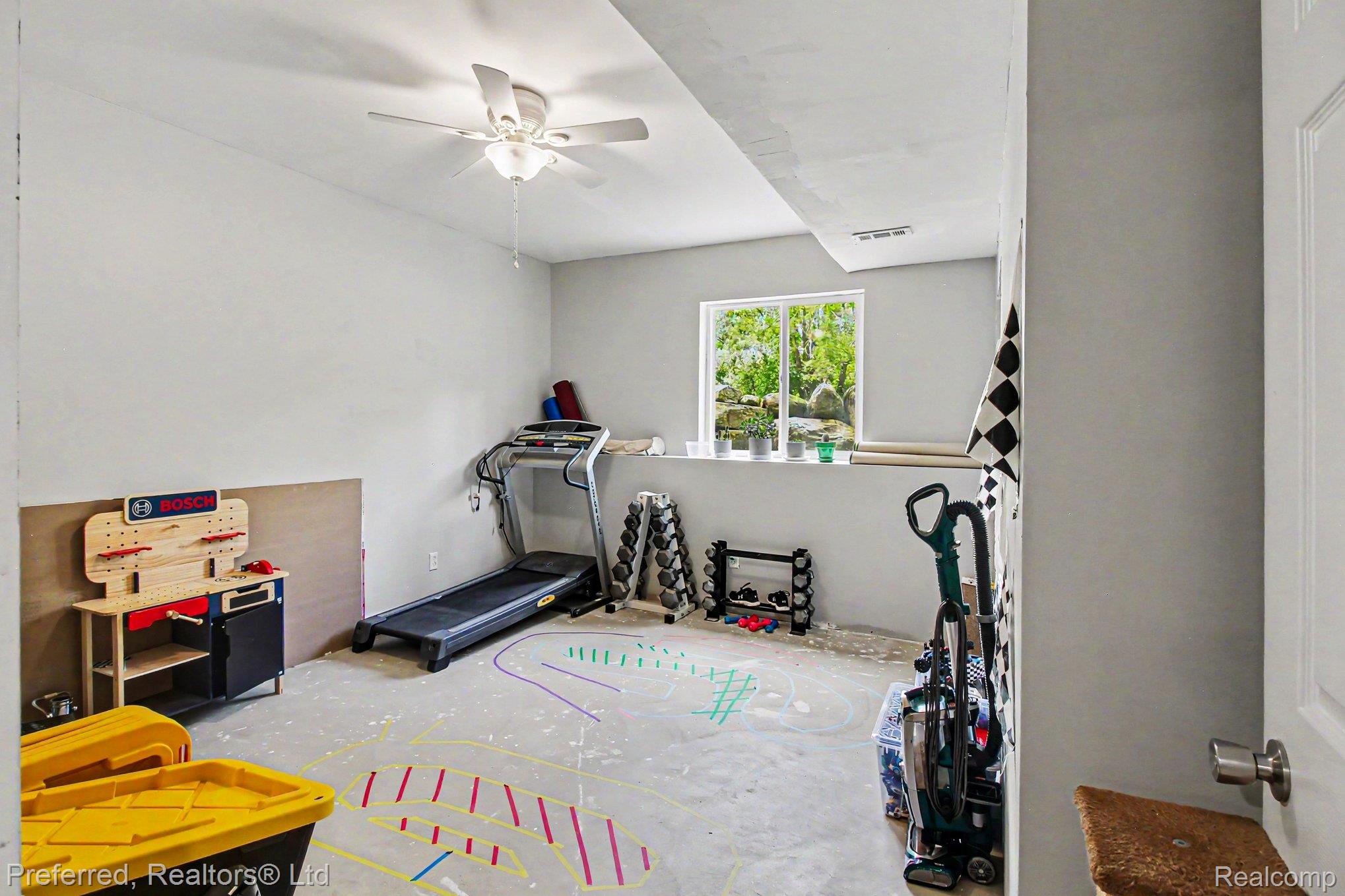 6366 Dutcher Road Howell, MI 48843 - Photo 21 of 33 Finished lower-level space with a ceiling fan, recessed lighting, and a window with outdoor landscaping visible