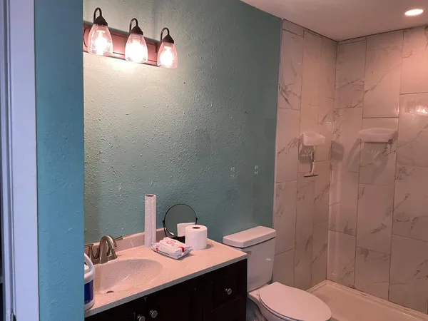a bathroom with a sink toilet and shower