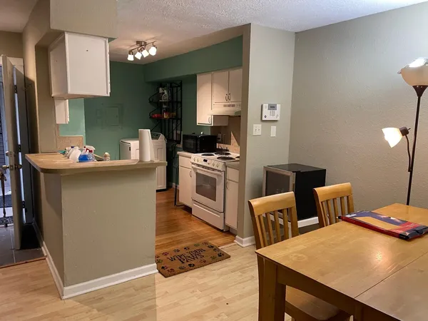 a kitchen with a table chairs and a refrigerator