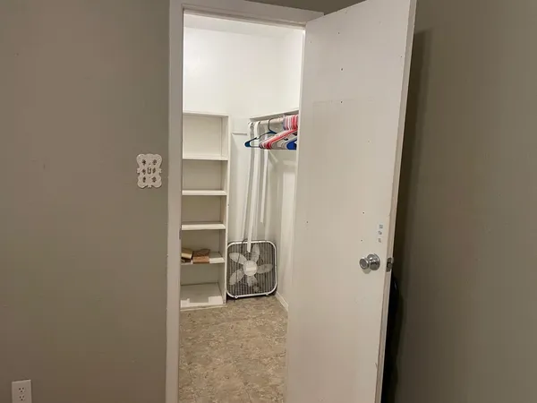 a view of walk in closet with empty racks