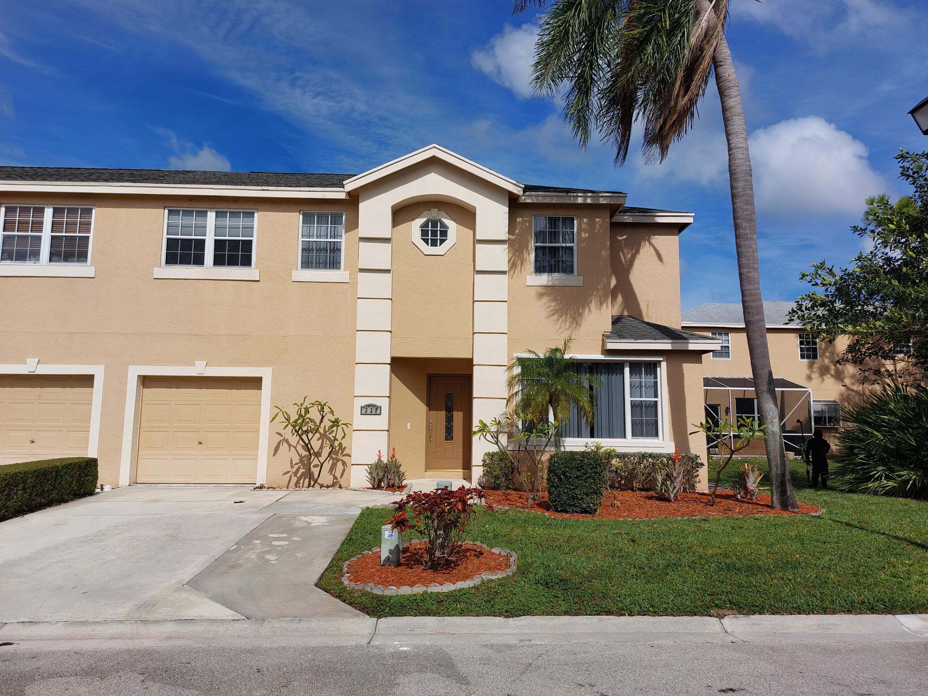 331 Oak Crest Terrace, Unit 331 Jupiter, FL 33458 - Photo 1 of 29 a front view of a house with garden