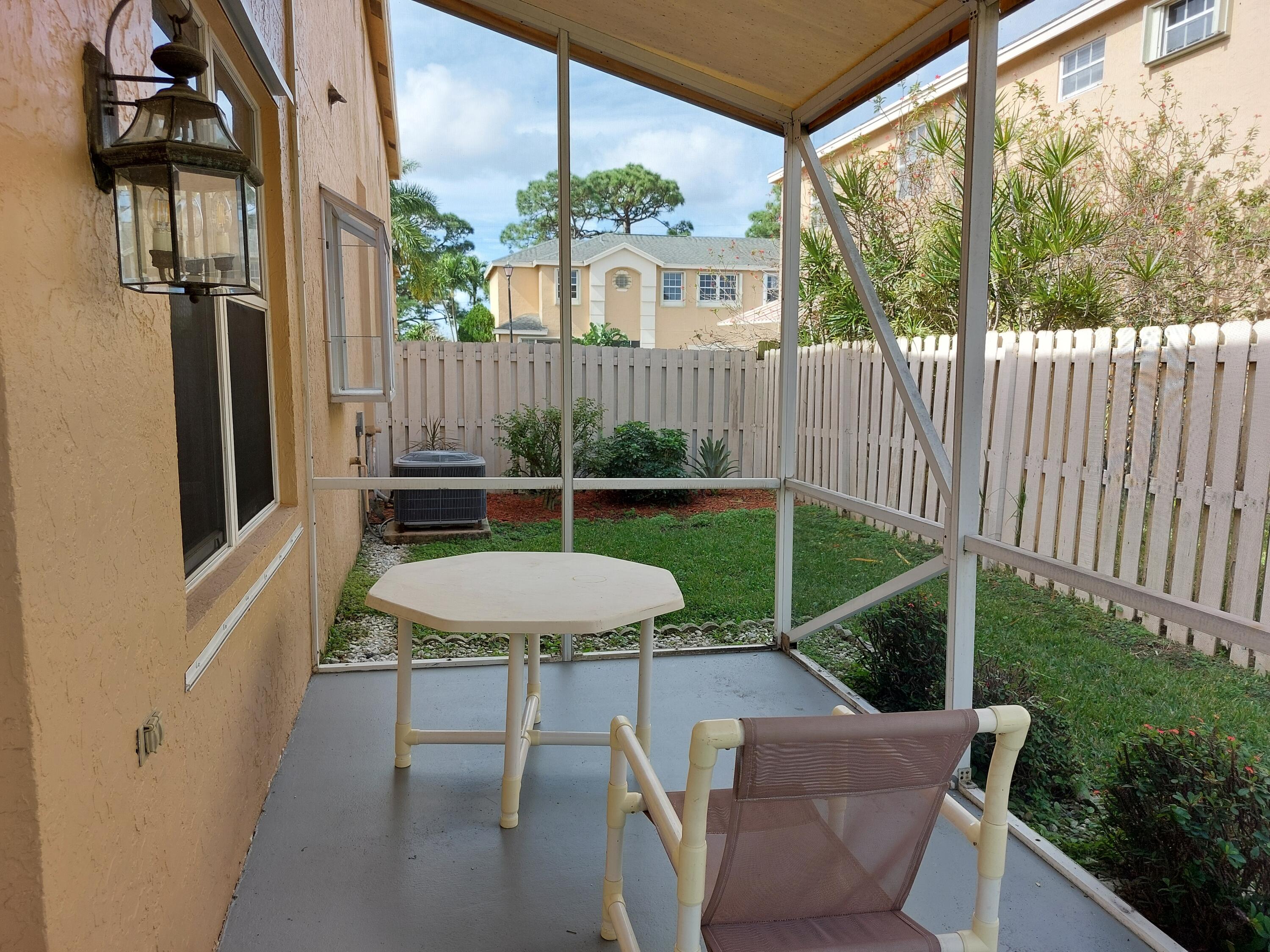 331 Oak Crest Terrace, Unit 331 Jupiter, FL 33458 - Photo 28 of 29 a view of a chair and table in backyard of the house