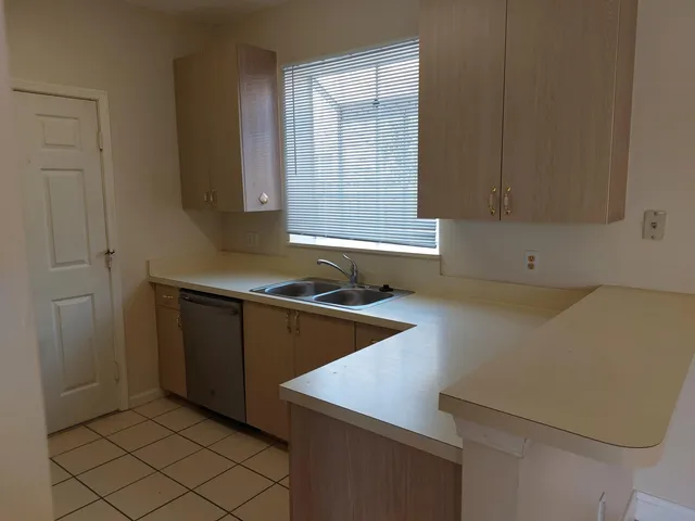 a kitchen with a sink cabinets and window
