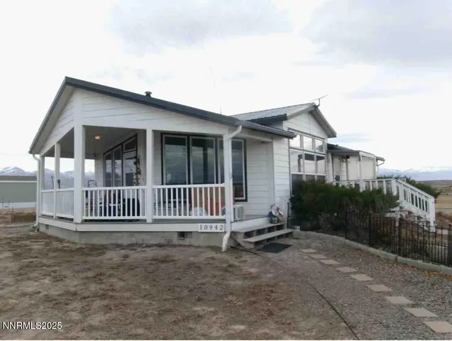 a view of a house with a small yard and wooden fence