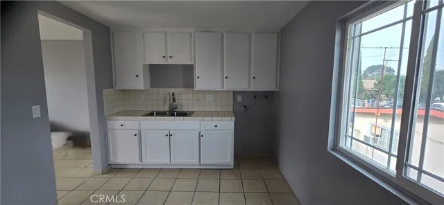 a kitchen with stainless steel appliances granite countertop a stove a sink and white cabinets