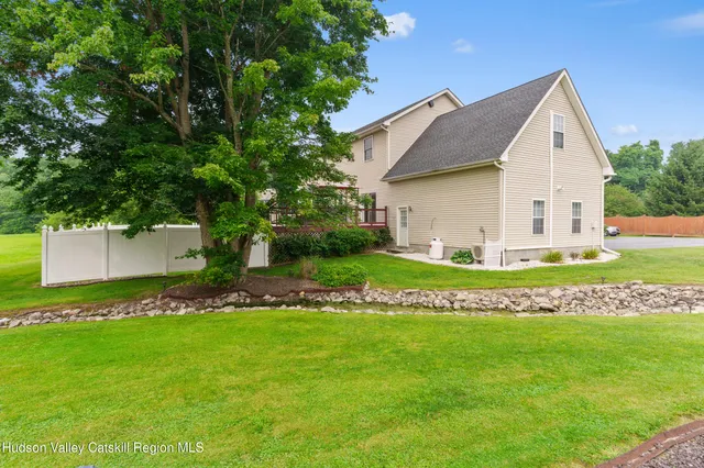 a backyard of a house with table and chairs under an umbrella