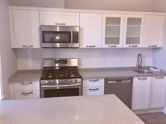 a kitchen with stainless steel appliances granite countertop a stove and a microwave