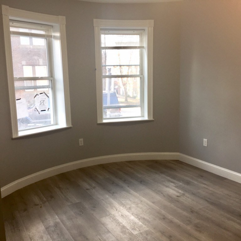 7 Leicester Street, Unit 2 Boston, MA 02135 - Photo 7 of 9 a view of an empty room with wooden floor and a window