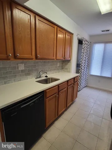 a kitchen with a sink window and cabinets