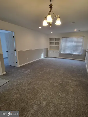 an empty room with a mirror and a chandelier fan