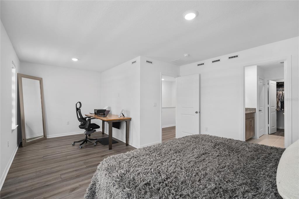 655 Clark Street Oviedo, FL 32765 - Photo 24 of 44 a spacious bedroom with a bed and a table in it