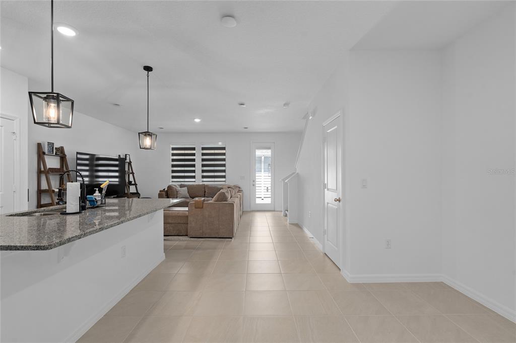 655 Clark Street Oviedo, FL 32765 - Photo 6 of 44 a large living room with stainless steel appliances kitchen island granite countertop furniture and a wooden floor