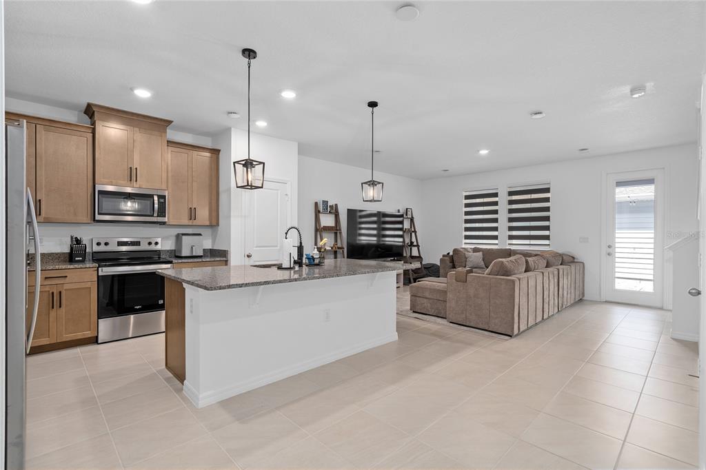 655 Clark Street Oviedo, FL 32765 - Photo 7 of 44 a kitchen with stainless steel appliances kitchen island granite countertop a stove a sink a oven a refrigerator and a refrigerator