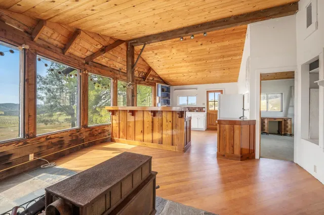 a room with wooden floor table and chairs