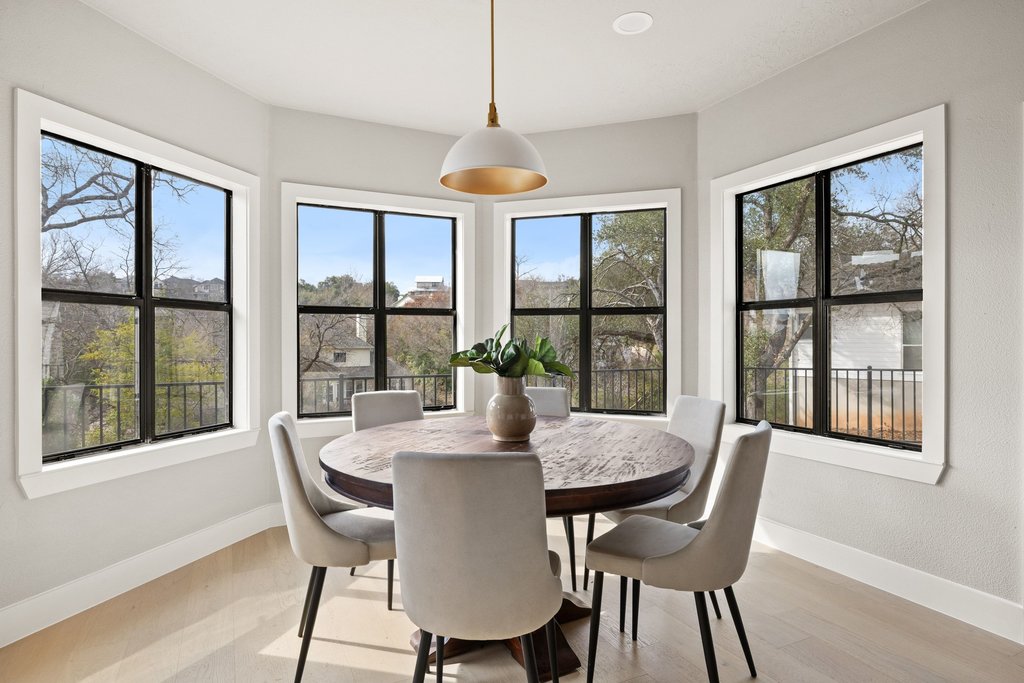 6311 Rusty Ridge Drive Austin, TX 78731 - Photo 13 of 37 a view of a dining room with furniture large windows and wooden floor