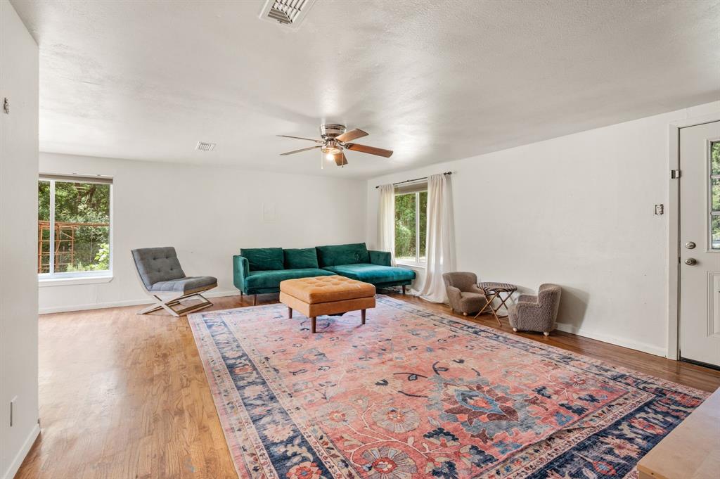 3900 Moseley Road Cross Roads, TX 76227 - Photo 4 of 36 Spacious living area featuring wood-finish flooring, white walls, and multiple windows