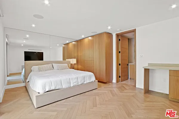 a bedroom with a bed chair and a large window