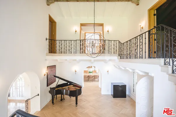 a living room with furniture chandelier and a large window