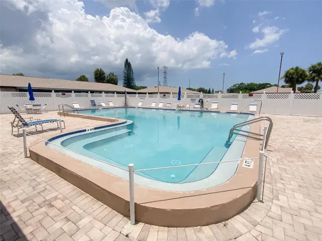 a view of a swimming pool with lawn chairs