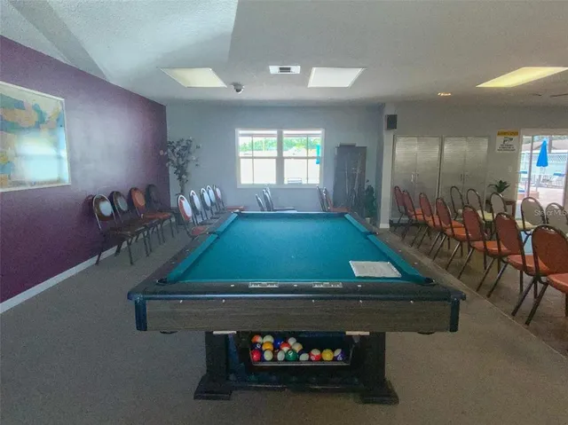 a room with pool table and windows