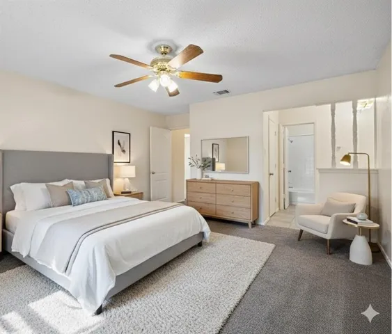 a spacious bedroom with a bed and a chandelier