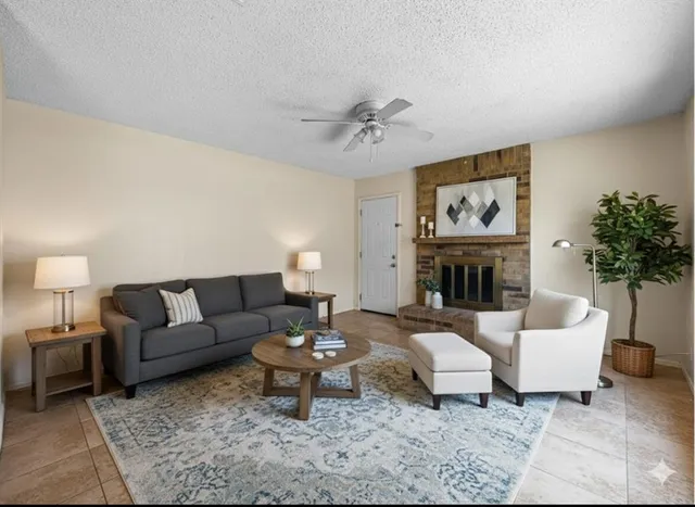 a living room with furniture a fireplace and a potted plant
