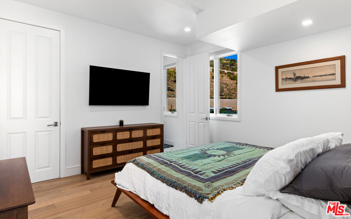 25157 Malibu Road Malibu, CA 90265 - Photo 20 of 33 a bedroom with a bed and a flat screen television