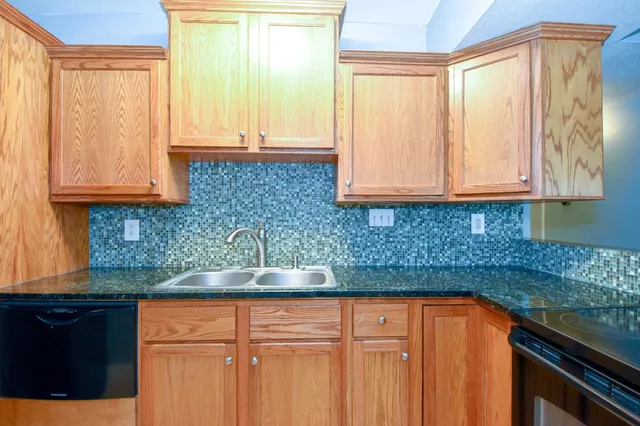 a kitchen with granite countertop cabinets and window