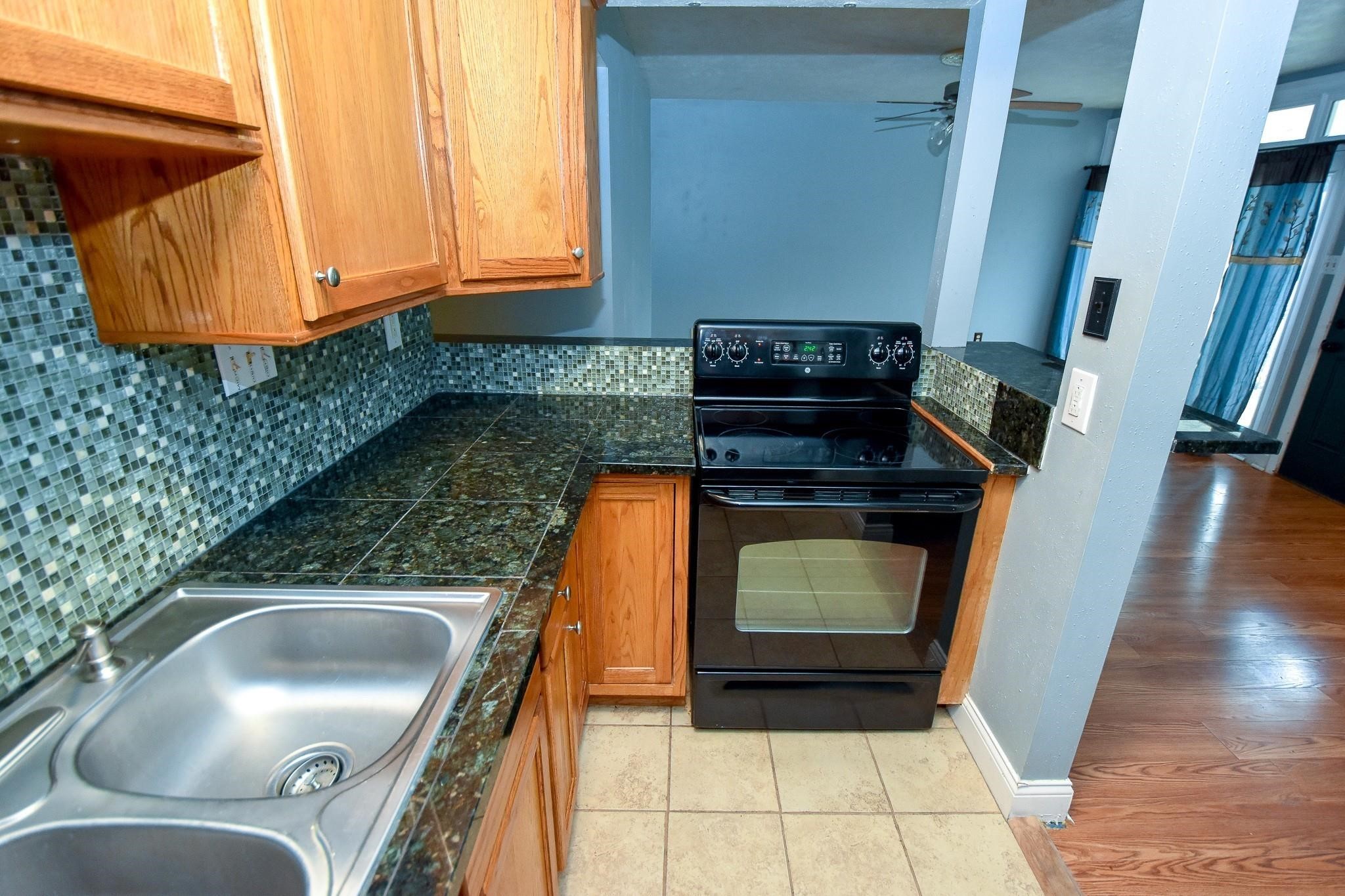 3400 Timmons Lane, Unit 78 Houston, TX 77027 - Photo 13 of 20 a kitchen with granite countertop a sink and a stove