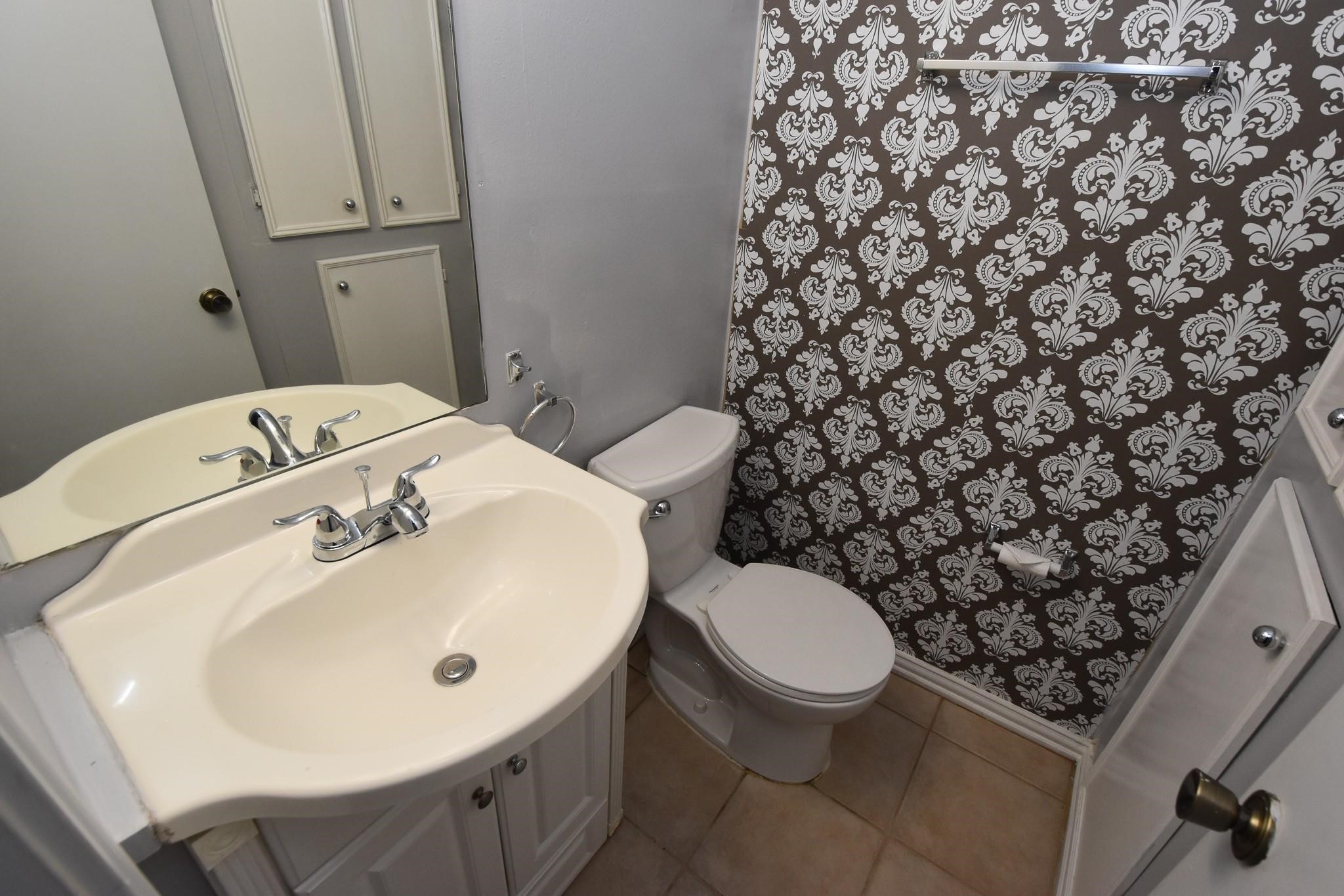 3400 Timmons Lane, Unit 78 Houston, TX 77027 - Photo 16 of 20 a bathroom with a sink toilet and a mirror