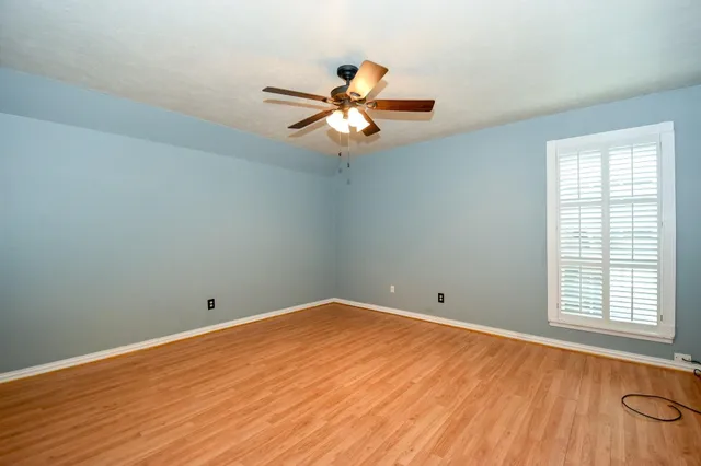 wooden floor in an empty room with a window