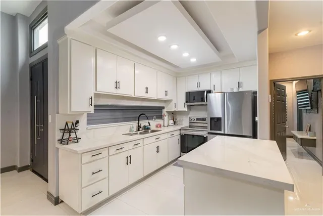 a kitchen with appliances a sink and cabinets
