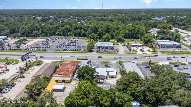 an aerial view of residential houses with outdoor space and trees