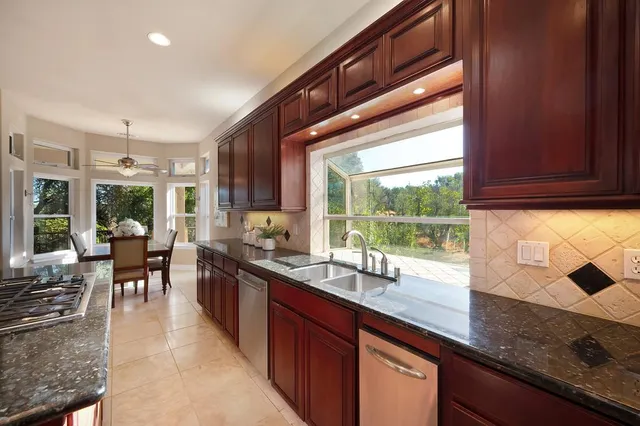 a bathroom with a granite countertop sink a large mirror and a toilet