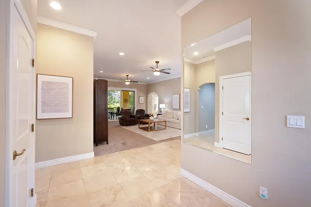 a living room with furniture a chandelier and a flat screen tv