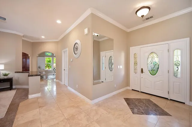 a living room with furniture and a large mirror next to a window