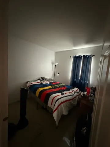 a bed sitting in a bedroom next to a window