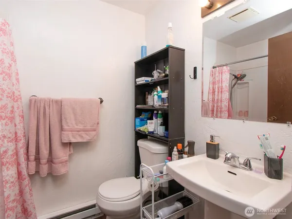 a bathroom with a sink a toilet and shower curtain