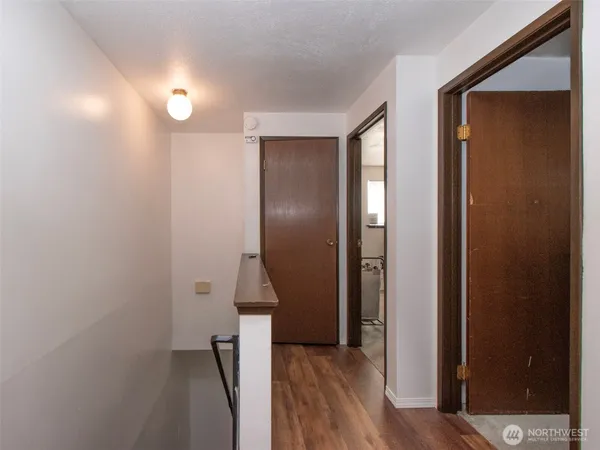 an empty room with wooden floor and a bathroom