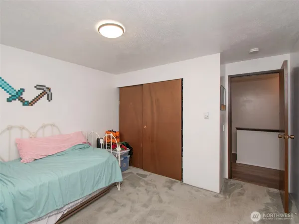 a bedroom with a bed and a refrigerator